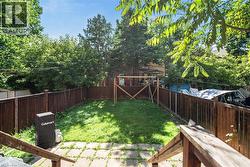 Private backyard with a full perimeter wood fence, featuring a central grass area and a paver stone patio - 