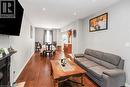 Open-concept living and dining area featuring wood-finish flooring, recessed lighting, and light gray wall tones - 38 Fairleigh Avenue N, Hamilton, ON 