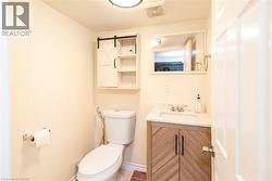Bathroom featuring a floating vanity with a marble-finish countertop, undermount sink, and a modern barn door-style medicine cabinet with open shelving - 