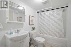White bathroom featuring a single vanity, mirrored medicine cabinet, toilet, and a shower-over-tub combination - 
