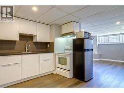 Kitchen towards living room in basement suite. - 