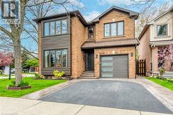Brick facade home featuring a prominent two-story bay window with horizontal siding accents - 