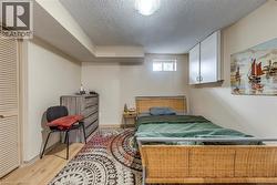 Room featuring light wood-finish flooring, a louvered closet door, a flush-mount ceiling light fixture, and an elevated window - 