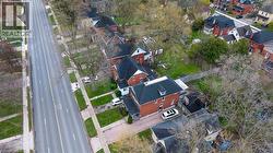 Aerial perspective showcasing a multi-story brick residence with a dark-pitched roof - 
