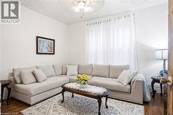 Living area featuring light wood-finish flooring, white walls, and a ceiling fan with integrated lighting virtual painted walls - 
