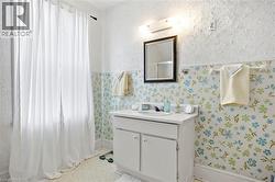 Bathroom featuring a single vanity with a white countertop and cabinet storage - 