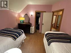 Bedroom featuring sloped ceilings, wood-finish flooring, and a built-in closet - 