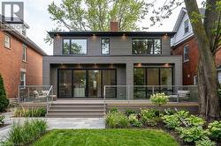 VIRTUAL DESIGN  IDEAS - REBUILDING HOUSE  2 STORY ADDITION -Contemporary rear exterior with gray horizontal siding, an expansive deck featuring glass railings, multiple large windows, and sliding glas - 