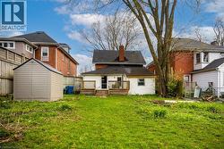 Spacious backyard featuring a large shed, a wooden privacy fence, and a deck with stairs accessing the rear of the home - 