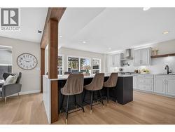 Entertain with ease in this stunning kitchen featuring quartz countertops, a massive waterfall island with bar seating, wine fridge, pot filler, pantry, and an abundance of storage. - 