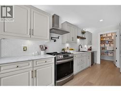 Equipped with stainless steel appliances and a convenient pot filler, this kitchen blends style and functionality for everyday cooking and entertaining. - 