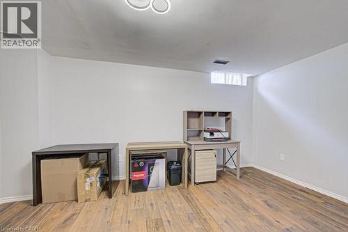 Versatile room featuring wood-finish flooring, white walls, and an overhead light fixture - 854 Elgin Street N, Cambridge, ON 