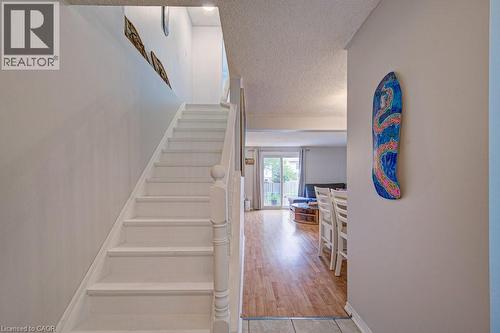 White painted staircase with a traditional newel post and balusters - 854 Elgin Street N, Cambridge, ON 