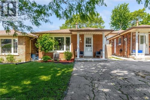 Brick exterior residence with a covered front porch and a white entry door - 338 East 24Th Street, Hamilton, ON 