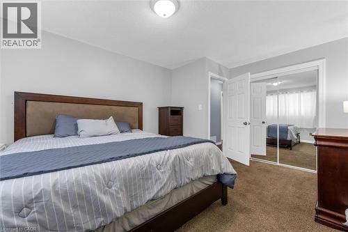 Bedroom featuring light gray walls, brown carpet flooring, and a flush mount ceiling light - 338 East 24Th Street, Hamilton, ON 