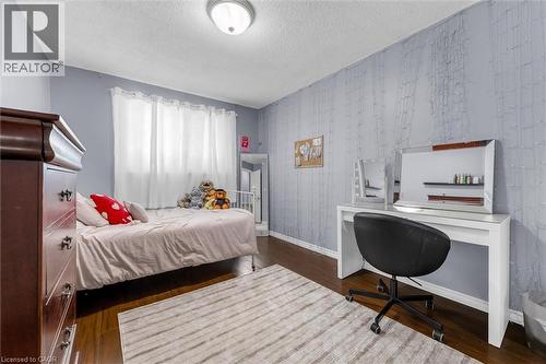 Wood-finish flooring throughout, complemented by light blue walls and a white textured accent wall - 338 East 24Th Street, Hamilton, ON 