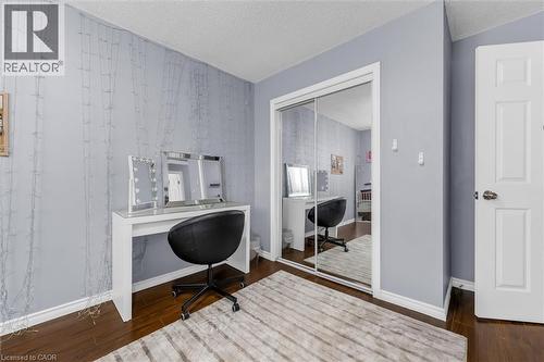 Interior room featuring dark wood-finish flooring, light grey walls, and white baseboards - 338 East 24Th Street, Hamilton, ON 