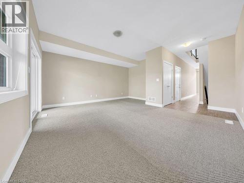 Spacious room with neutral-toned walls, light-colored carpet flooring, and white baseboards - 60 Arkell Road Unit# 51, Guelph, ON 