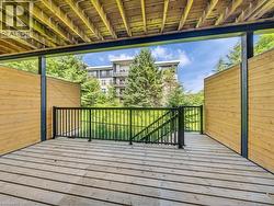 Spacious outdoor deck featuring wood-finish flooring, black metal railings, and natural wood privacy screens - 