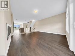 Spacious interior featuring wood-finish flooring, light neutral wall tones, and recessed ceiling lighting - 