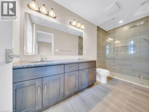 Contemporary bathroom featuring a dual vanity with granite-style countertop, undermount sinks, and wood-finish cabinetry - 60 Arkell Road Unit# 51, Guelph, ON 