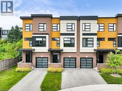 Contemporary townhome exterior featuring brick, horizontal wood-finish siding, and smooth panels - 
