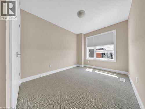 Neutral tone walls with white trim, a single window with blinds, and light-colored carpet flooring - 60 Arkell Road Unit# 51, Guelph, ON 