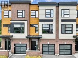 Modern townhome facade featuring a brick base, wood-panel siding, and contemporary window designs - 
