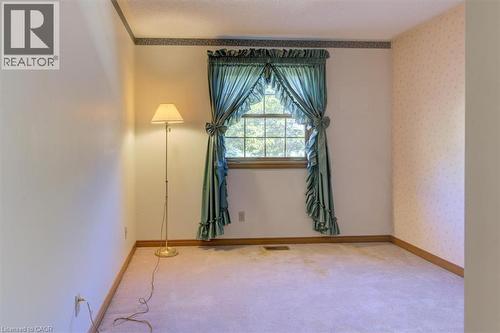 Upper North-East Bedroom 2: This cozy bedroom features soft carpet and charming wood trim, perfect for relaxation and quiet mornings. - 42 Donly Drive S Unit# 2, Simcoe, ON 