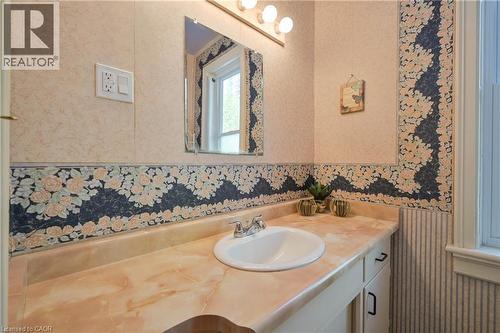 Bathroom vanity featuring a built-in sink, dual-door cabinetry, and an expansive countertop - 25 Ahrens Street W, Kitchener, ON - Indoor Photo Showing Bathroom