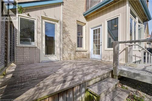 Spacious wood deck with two entry points, featuring a partial lattice railing and two steps to ground level - 25 Ahrens Street W, Kitchener, ON - Outdoor