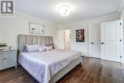 Spacious room featuring wood-finish flooring, white walls, and crown molding - 