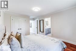 Hardwood flooring extends through the room, complemented by white crown molding and baseboards - 