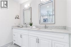 Dual white vanities featuring integrated sinks and stone-finish countertops - 