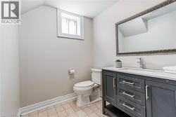 Bathroom featuring a dark grey vanity with a white countertop and an undermount sink - 