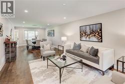 Open-concept living and dining areas featuring recessed lighting, crown molding, and wood-finish flooring - 