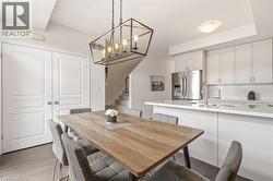 Open-concept dining area featuring a linear chandelier with exposed bulbs - 