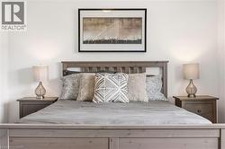 Bedroom featuring a wood-finish bed frame and matching nightstands - 