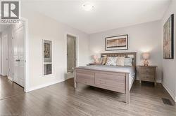 Spacious bedroom featuring wood-finish flooring, light neutral wall tones, and a built-in closet with bifold doors - 