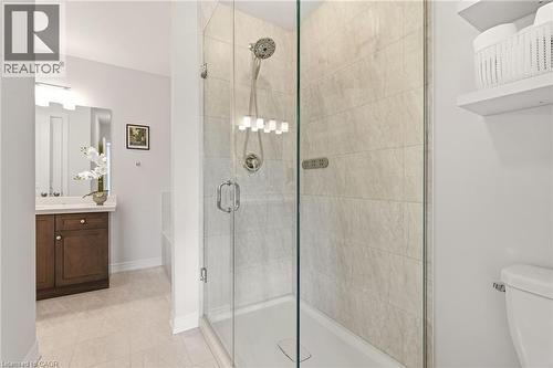 Glass-enclosed shower featuring a tiled surround and dual shower heads - 4171 Palermo Common, Burlington, ON - Indoor Photo Showing Bathroom