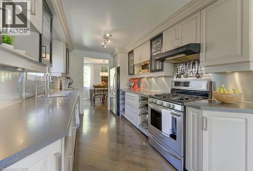 Kitchen featuring stainless steel appliances, light-toned cabinetry, solid surface countertops, hardwood flooring, and recessed lighting - 108 Clearwater Crescent, Waterloo, ON - Indoor Photo Showing Kitchen With Upgraded Kitchen