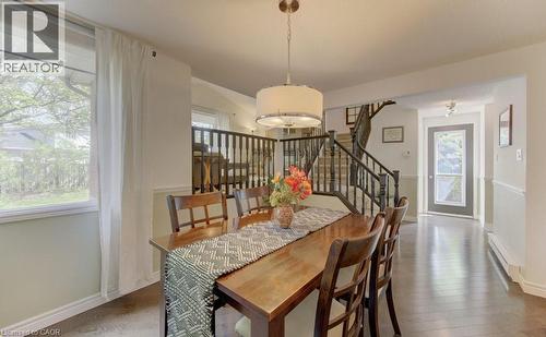 Dining area featuring dark wood-finish flooring, a drum-style ceiling fixture, and a large window - 108 Clearwater Crescent, Waterloo, ON - Indoor Photo Showing Dining Room