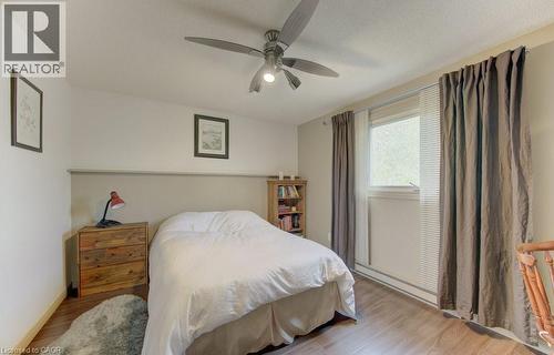 Bedroom featuring wood-finish flooring, a ceiling fan with integrated lighting, a window with horizontal blinds, and a built-in bookshelf - 108 Clearwater Crescent, Waterloo, ON - Indoor Photo Showing Bedroom
