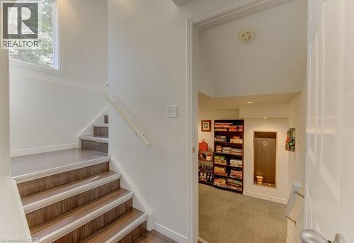 Stairwell featuring wood-finish treads with white risers, white baseboards, and a white handrail - 108 Clearwater Crescent, Waterloo, ON - Indoor Photo Showing Other Room