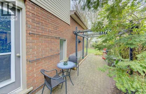 Brick exterior featuring a screen door, a small window, and a paver patio - 108 Clearwater Crescent, Waterloo, ON - Outdoor With Exterior