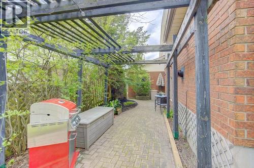 Brick exterior with an expansive side patio featuring a wood pergola - 108 Clearwater Crescent, Waterloo, ON - Outdoor With Exterior