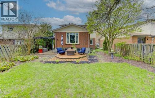 Expansive green space featuring a multi-level wood-finish deck with integrated seating, a pergola, and mature trees - 108 Clearwater Crescent, Waterloo, ON - Outdoor