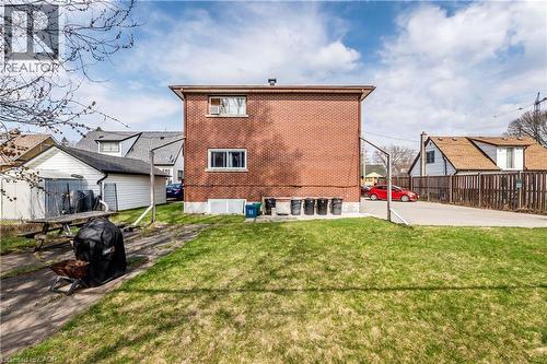 Expansive backyard featuring a manicured lawn, brick exterior, multiple windows, and a detached garage - 43 Sixth Avenue, Kitchener, ON - Outdoor With Exterior