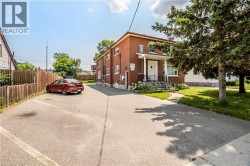 Brick exterior structure with white trim windows and a covered entrance featuring decorative pillars - 
