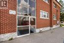 Red brick exterior with multiple windows, a glass-paneled entrance, and a concrete foundation - 43 Sixth Avenue, Kitchener, ON  - Outdoor With Exterior 